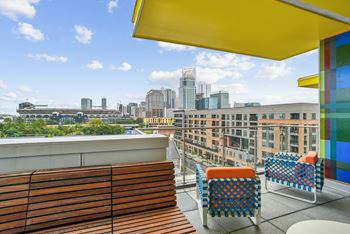 a rooftop terrace with chairs and a view of the city at Link Apartments® Mint Street, Charlotte